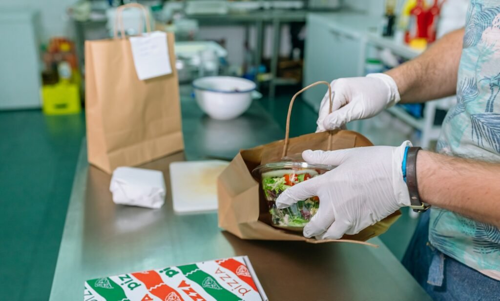 Unrecognizable cook packing a takeaway order